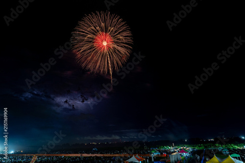 Three red willow fireworks rising together over festival crowd