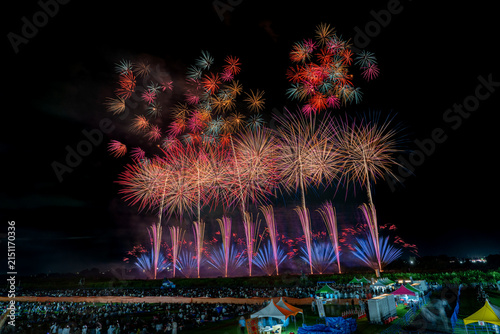 фотографія Scattered multicolor fireworks with red, orange and teal sparkling across night