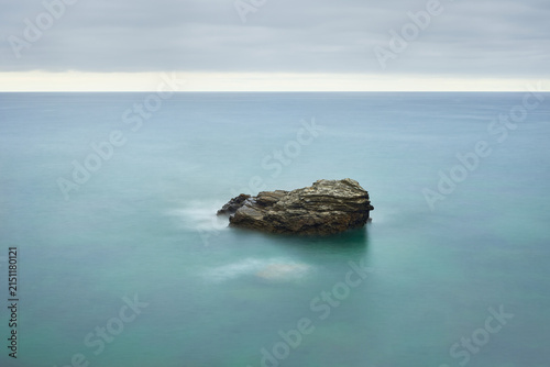 Moody long exposure of misty sea and rock at Praia das Catedrais, Beach of the Cathedrals in Ribadeo, Galicia Spain