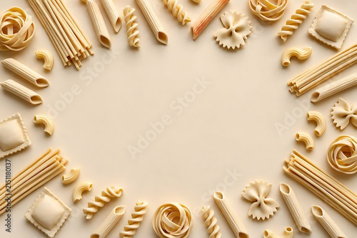 Assortment of various Italian pasta types arranged as a frame on a light background, top view
