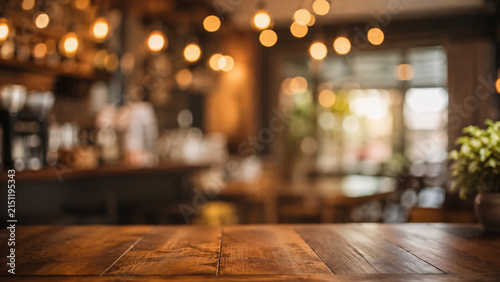 warmly lit cafe interior, bokeh background, wooden table in foreground, perfect for food and drink advertising, cozy atmosphere, evening ambiance