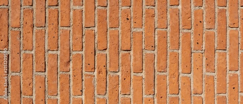 Closeup view of a textured orange brick wall pattern.