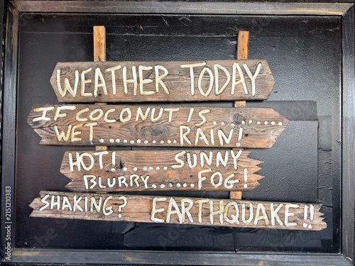 Foto Humorous weather coconut wooden sign predicting rain fog and earthquakes