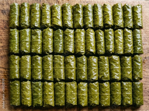 Delicious Homemade Dolmas Arranged On A Rustic Wooden Board, Ready To Be Served As A Healthy Appetizer.