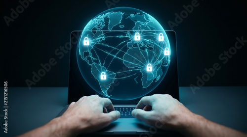 Hands typing on laptop keyboard with glowing digital globe security hologram