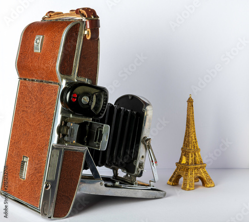 Obraz na płótnie vintage polaroid camera taking picture of miniature Eiffel Tower decoration on w