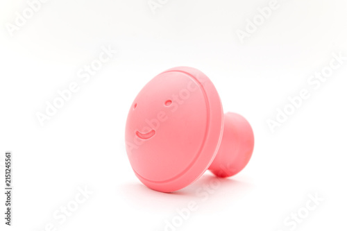 A pink, round facial massager. On a white background. Close-up.