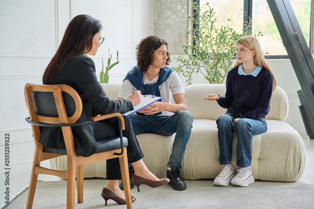 Fototapeta premium Teenagers talking to psychologist at therapy session