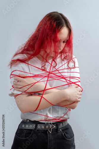 Quadro su tela Teenage girl with pink hair wrapped in red lines symbolizing imposed social rules, pressure and stereotypes, personal boundaries and conflict avoidance, fear of confrontation and self expression