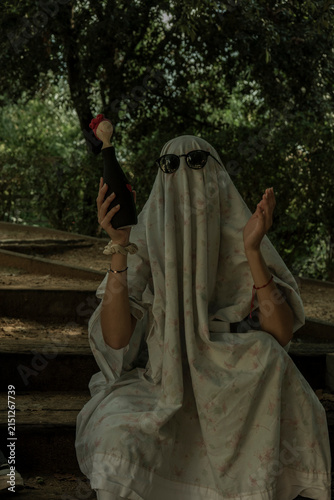 Person in Ghost Costume Sitting on Stairs in Woods