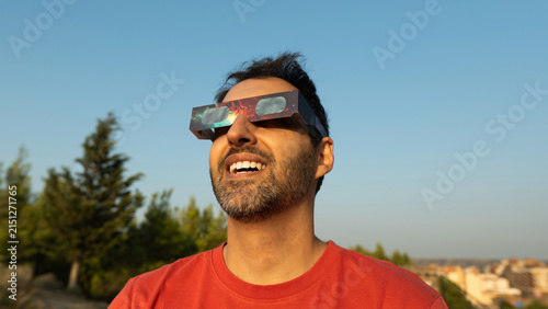 Man observing a solar eclipse safely with protective glasses