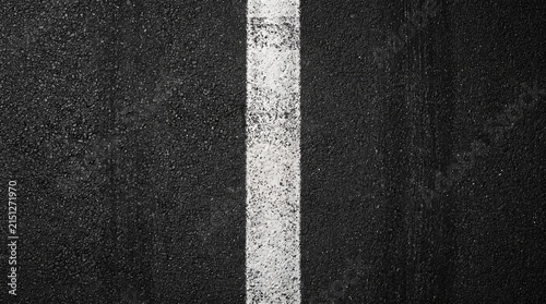 Abstract background of a single white line on black asphalt road surface