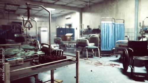Abandoned treatment bay after hasty evacuation with overturned beds, scattered linens, tangled wires, broken equipment, wheelchair lodged among debris,