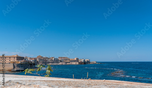 a wide-angle view of the sea and the deep blue sky of Syracuse, visible on the horizon