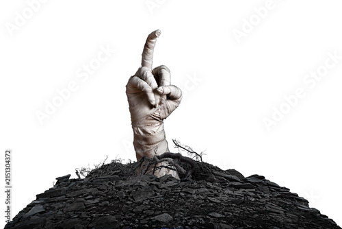 Mummy's hand wrapped in a bandage obscene gesture reaches up through the ground grave on isolated background. The hand of the mummy monster for Halloween horror concept