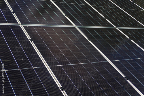 Solar panels installed on ground next to residential house generating clean green energy