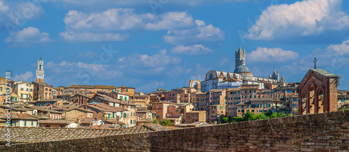 Siena, Province of Siena, Italy. Panoramic view of the old medieval city of Siena, also called the open-air museum city of Italy. In the background the Siena Cathedral (Duomo di Siena).