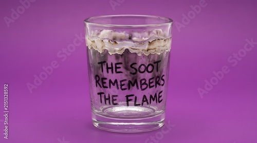 A glass stained with dark soot bearing poetic text against a vibrant purple backdrop, symbolizing lingering memories, residual passion, and emotional aftermath.