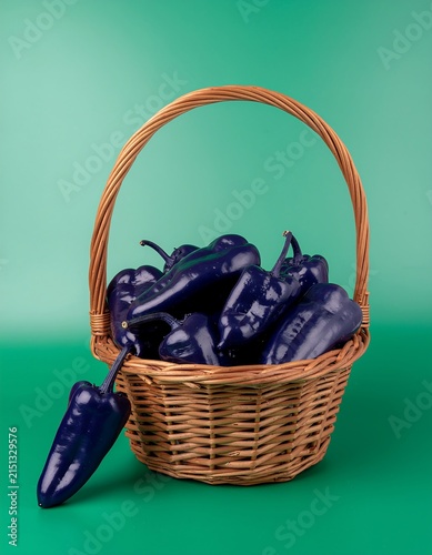 Basket filled with fresh ripe blackberries on woven mat.