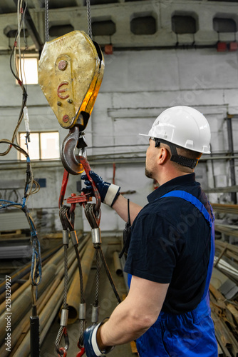 Canvastavla Industrial worker inspecting crane hook and wire rope slings in factory