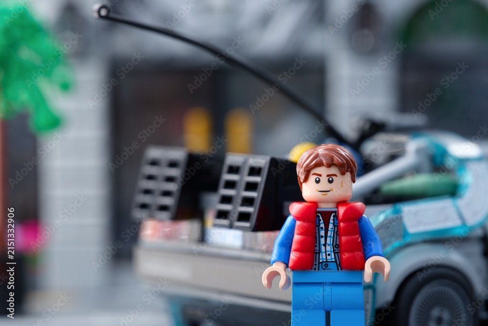 Fototapeta premium Tambov, Russian Federation - July 30, 2026 Lego Marty McFly minifigure standing near back of DeLorean time machine car from Back to the Future.
