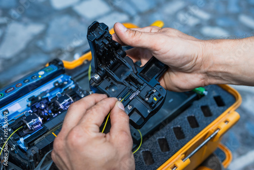 Canvastavla A man holding an optical fiber cleaver and cutting a fiber optic cable