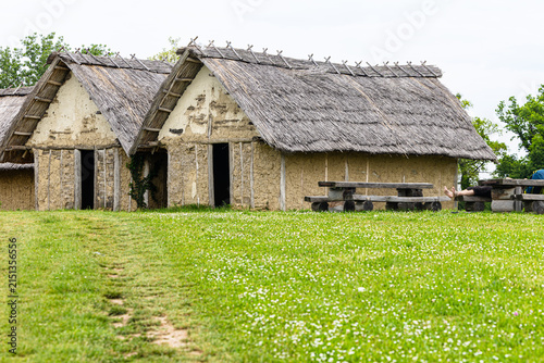 Thatched Huts in Historic Rural Village With Picnic Tables on Green Field, Sopot culture, Vinkovci, Croatia