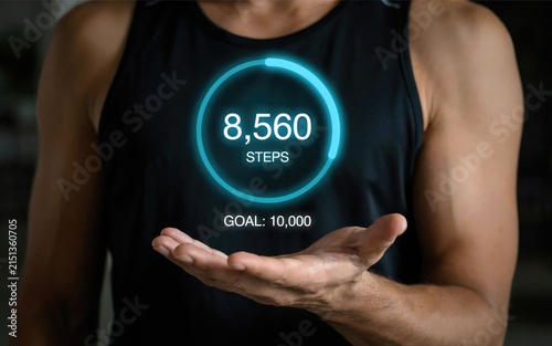 Man in black tank holding a glowing digital step counter hologram