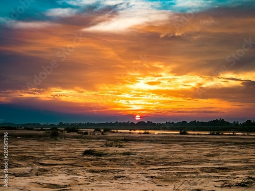 Obraz na płótnie A low autumn sun dips below the horizon, painting the crisp sky in fiery orange and soft violet