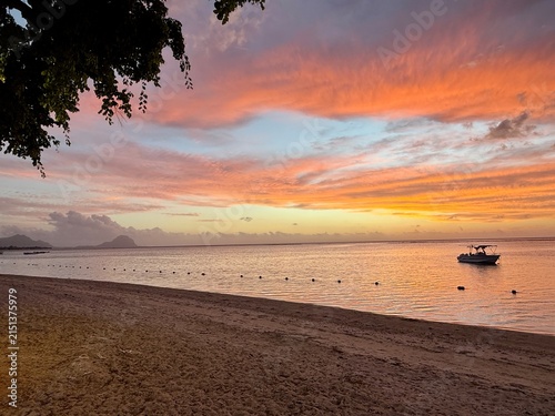  Sunset over a tropical beach — calm lagoon with boat and buoy line