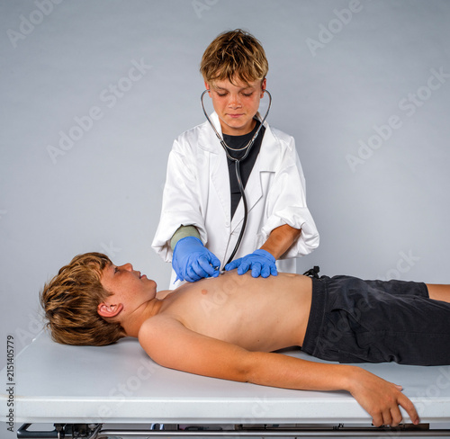 Konstfotografi Two boys playing doctor and patient during imaginative childhood role play