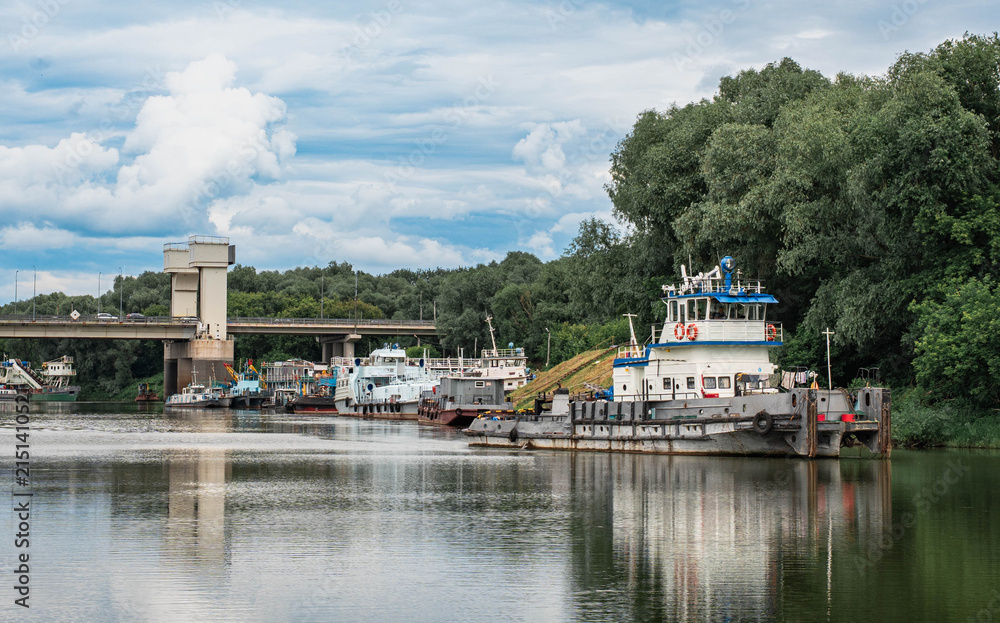 Fototapeta premium Push Tugboat Moored on River Near Bridge and Forest Bank