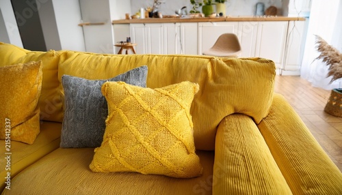 cozy yellow boucle sofa close up textured fabric throw pillow on modern modular couch warm and inviting living room interior design