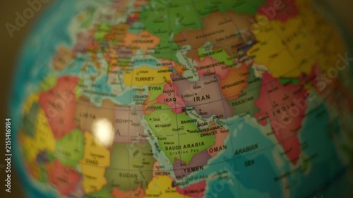 Globe spins slowly, highlighting Iran and surrounding nations. Colorful map details stand out with soft focus effects. Ideal for travel, geography, or global awareness themes