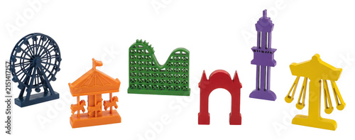 Colorful wooden amusement park ride game pieces including a Ferris wheel, roller coaster, and carousel are arranged in a playful collection showing various attractions for entertainment