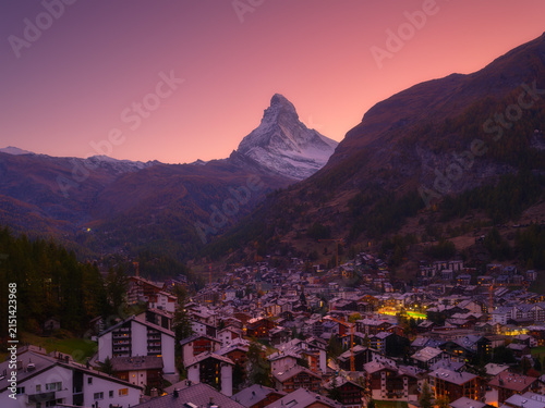 Sunset view over the town of Zermatt with Matterhorn mountain in the background. Evening light illuminates Swiss alpine village and peak.