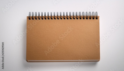 brown spiral bound notebook on white background