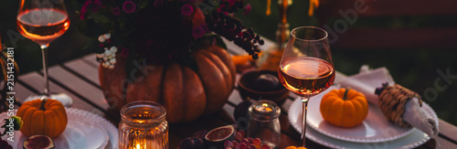 Banner. Beautiful elegant autumn table setting for thanksgiving family dinner or wedding. Pumpkin with flowers as centrepiece. Cozy fall home atmosphere. Wineglass, romantic marriage proposal, sunset