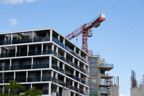 Foto Modern residential building with balconies adjacent to a construction site featu