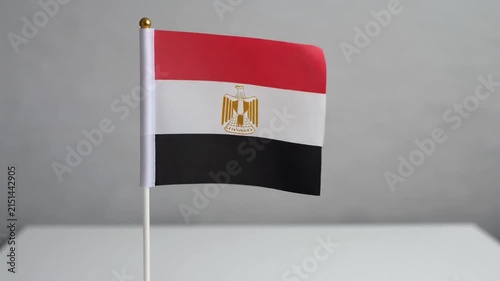 Small Egypt Flag Waving on White Table Desk Stand Isolated on Grey Background