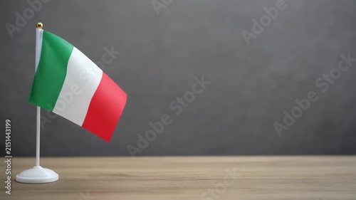 Small Italy Flag Waving on Wooden Table Desk Stand Isolated on Grey Background