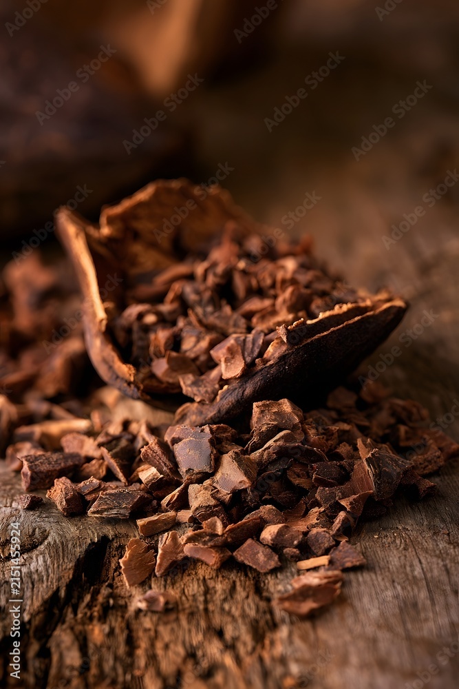 Fototapeta premium Cracked Cocoa Bean with Raw Nibs on Rustic Wood
