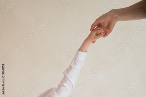 Obraz na płótnie Adult gently holding child's hand, symbol of guidance, safety, trust, parenting