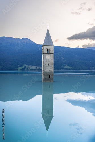 Submerged church tower reflected in a calm alpine lake