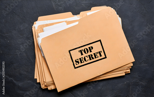 Yellow file with documents and Top Secret stamp on black table, top view