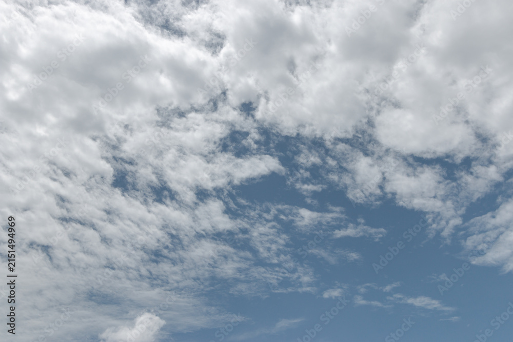 Obraz premium blue sky with a dramatic scattering of white clouds. blue sky background.