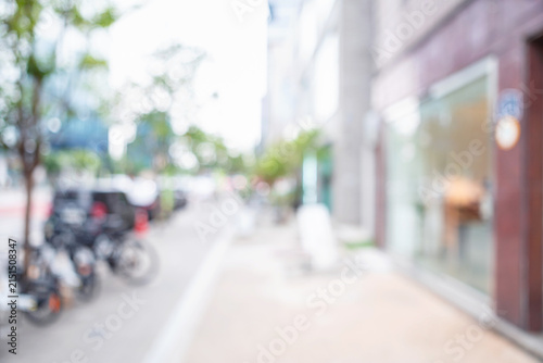 Abstract blurred modern urban shopping street background with storefronts and bicycles