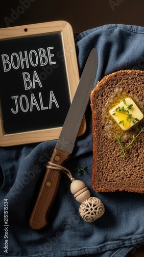 Gourmet bohobe ba joala dense sorghum bread with butter and micro thyme, elegant traditional presentation with deep brown copy space