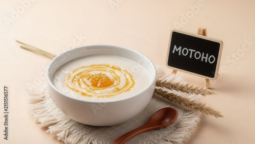 Gourmet silky motoho fermented sorghum porridge with honey and edible gold, elegant traditional presentation with soft beige copy space
