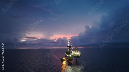 Aerial view of offshore jack up rig and offshore platform during sunset for oil and gas exploration and production. 